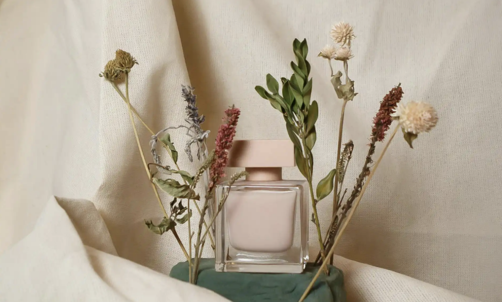 En pink parfume med blomster rundt om